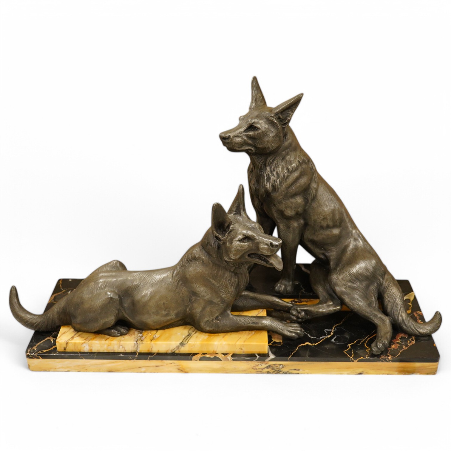 An Art Deco patinated metal Alsatian figure group raised on stepped base, 70cm wide. Condition - good, some chipping to the base